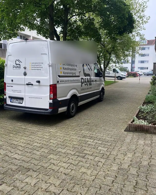 Geparkter Transporter des Partnerbetriebs im Hof eines Mehrfamilienhauses
